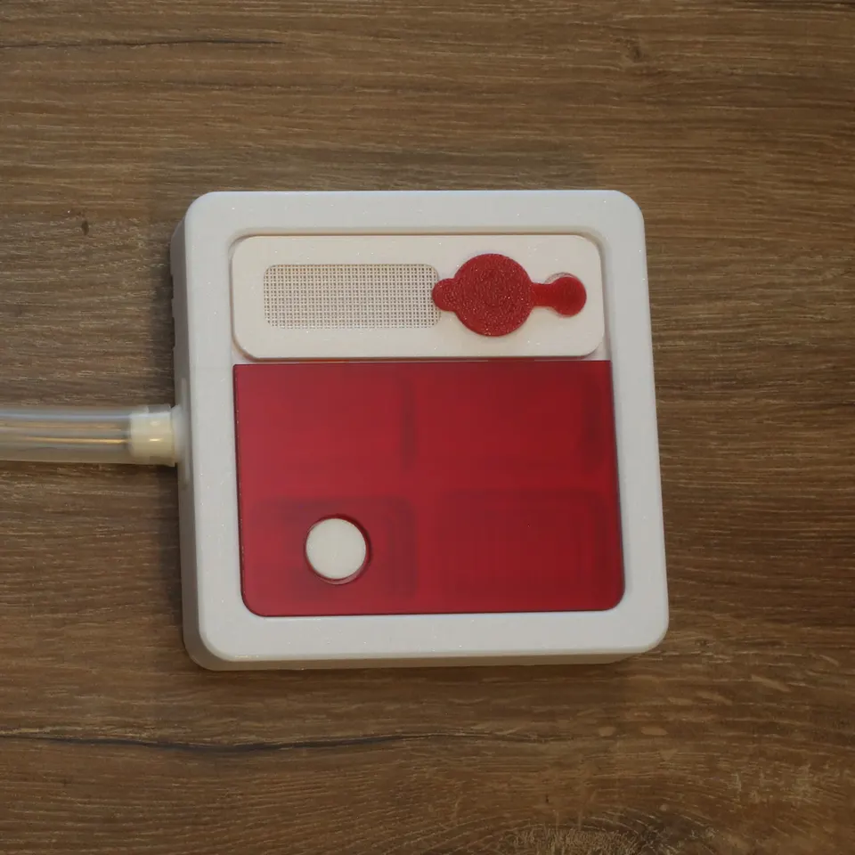 The Hybrid Nest Air from above with its red top on and a tube joined on the left