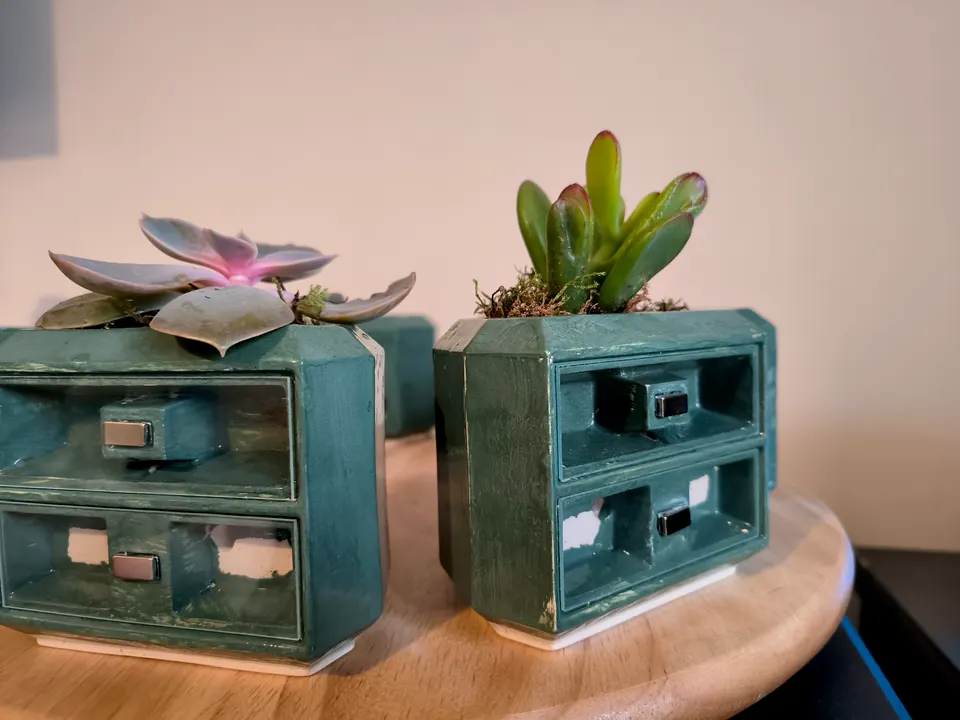 Two green prototypes side by side, each with a succulent on top