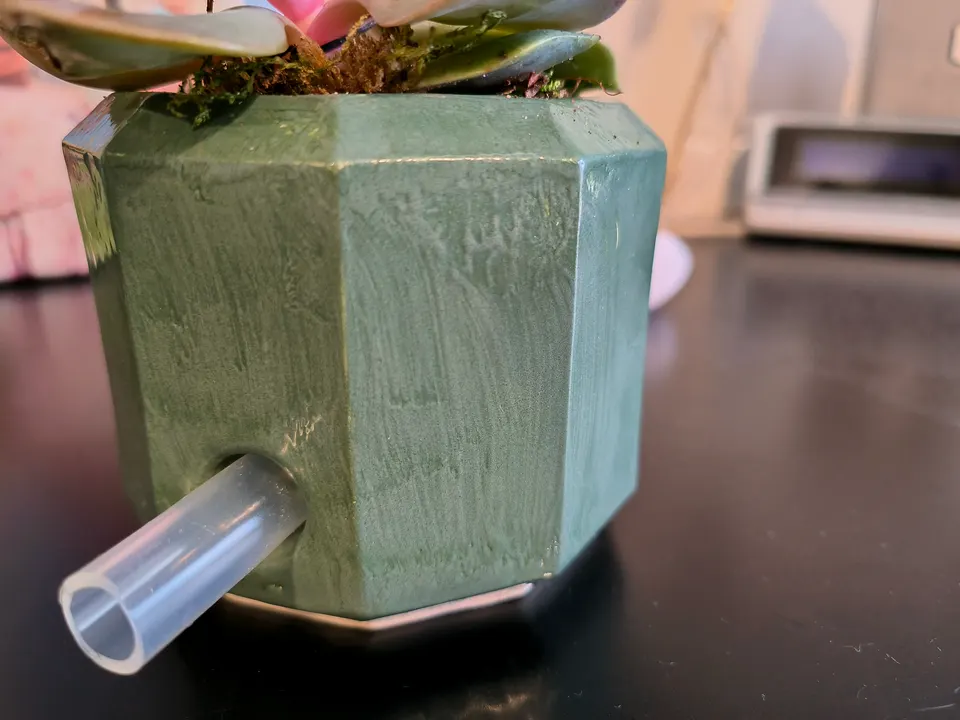 The back of a green prototype, with a clear tube coming out of the side